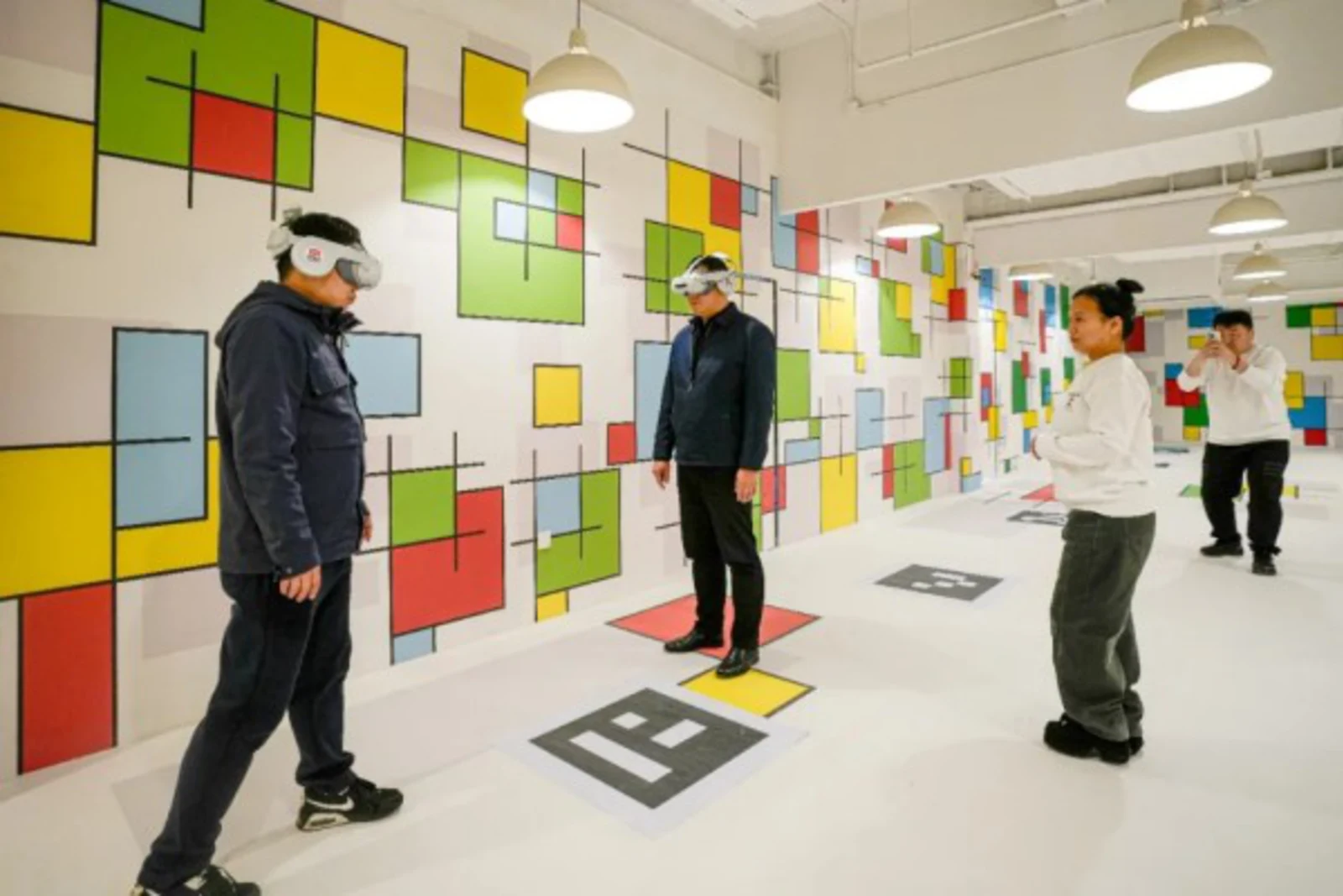 国漫VR基地の体験エリアでMRヘッドセットを装着する来場者と案内スタッフ