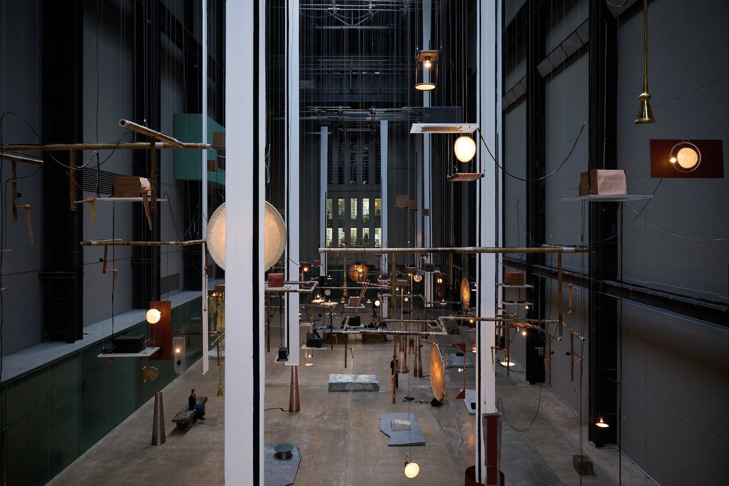 テート・モダンのタービン・ホールに楽器や彫刻を吊り下げた「Hold」の展示風景
